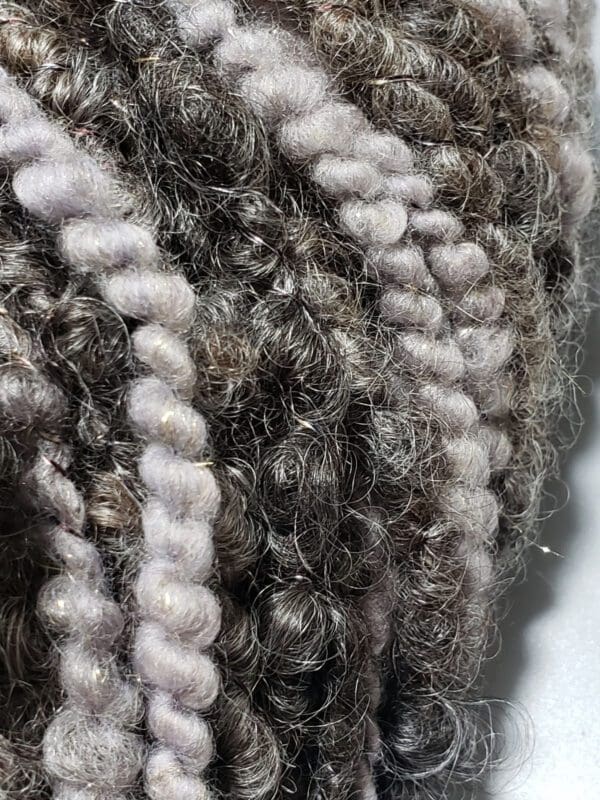 A close up of a ball of grey and white yarn.