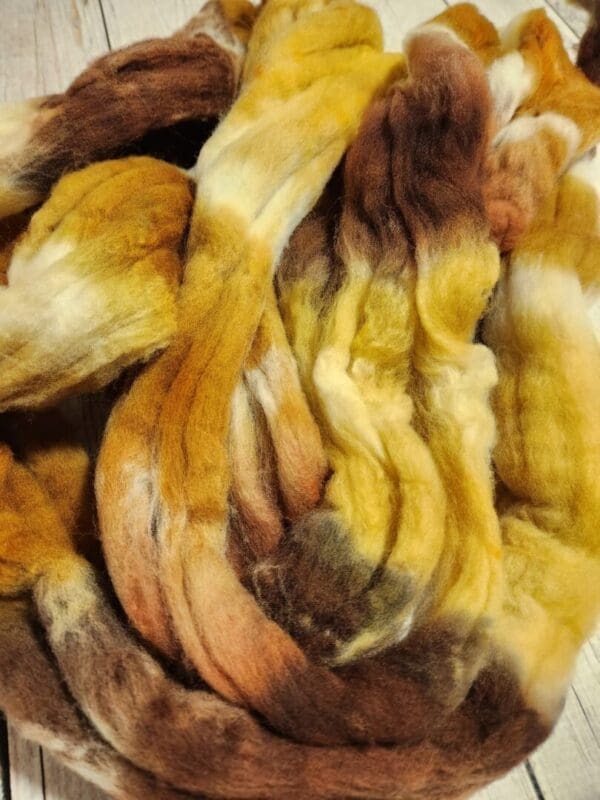 A skein of brown, yellow, and white roving.