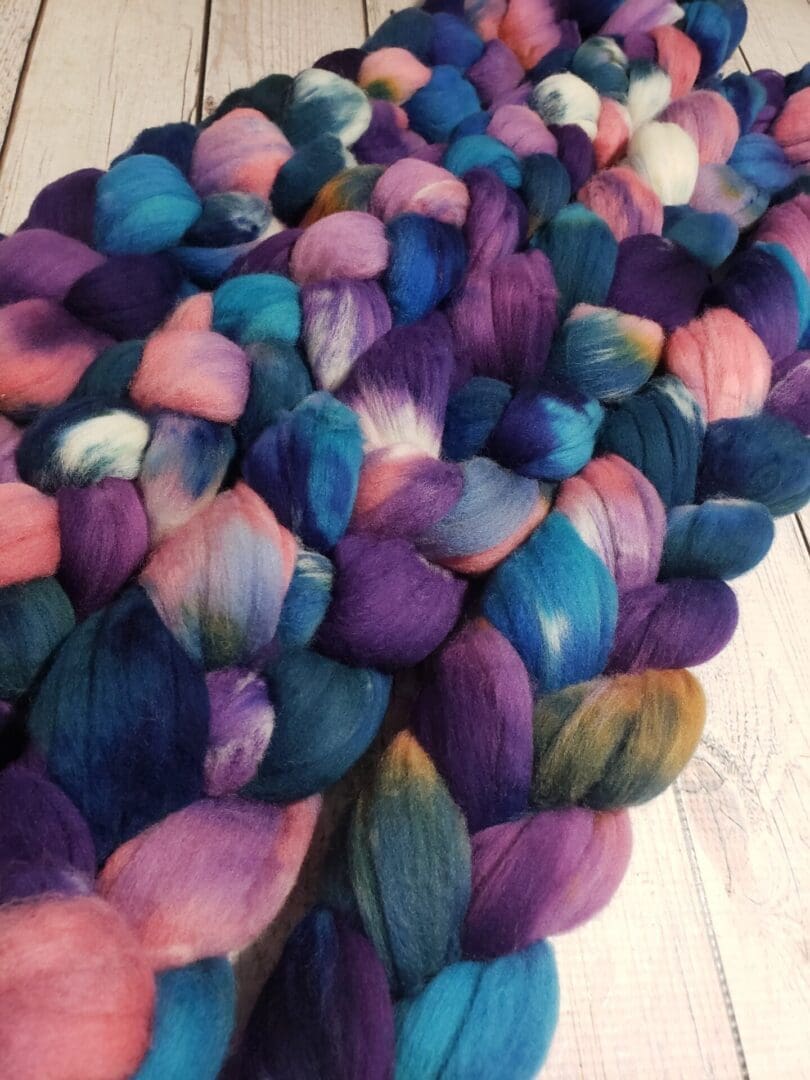 A pile of purple, blue, and pink roving.