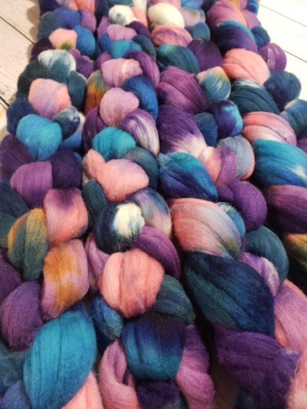 A pile of purple, blue, and pink roving.