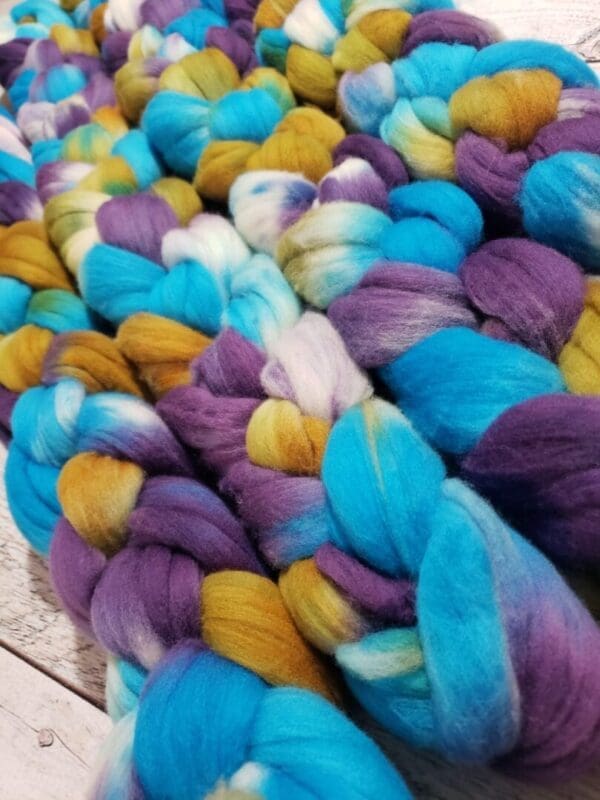 A pile of blue, yellow, and purple roving.