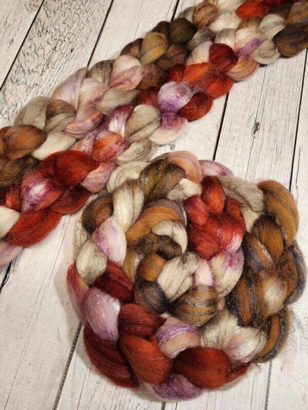 A skein of merino roving on a wooden table.