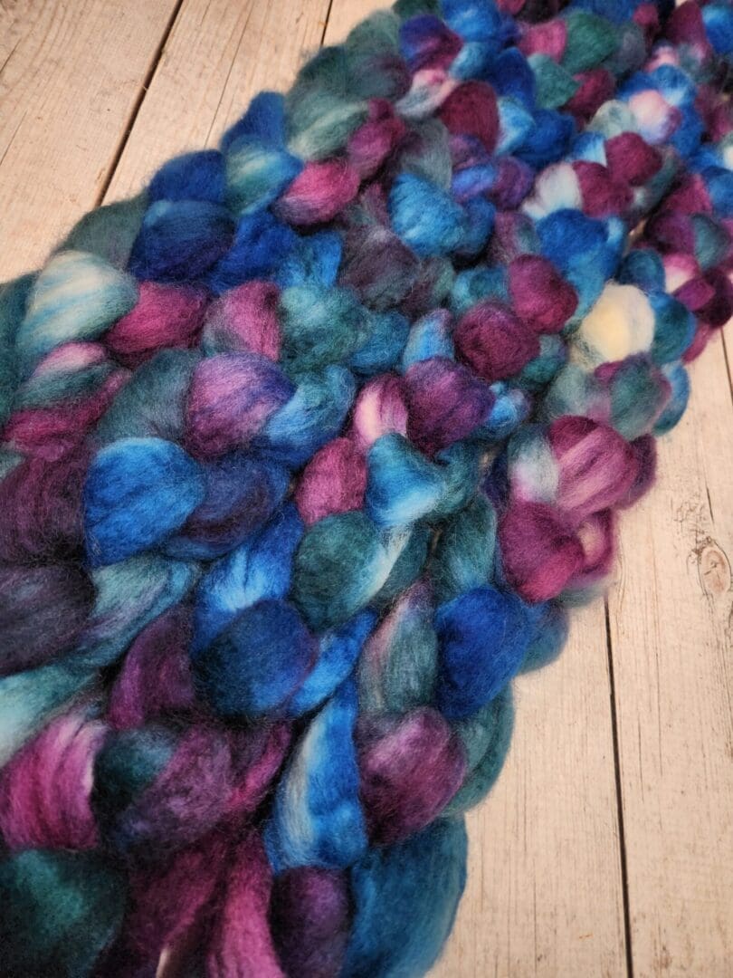 A skein of Disco Date ~ 100g Hand-Dyed Luxury Combed Top Fiber.