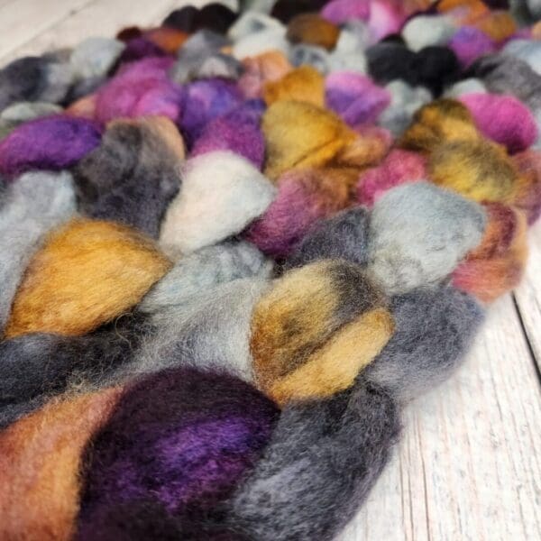 A close up of a pile of Disco Date ~ 100g Hand-Dyed Luxury Combed Top Fiber.