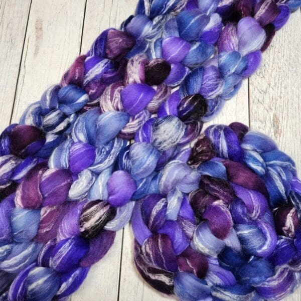 Purple and blue roving on a wooden table.