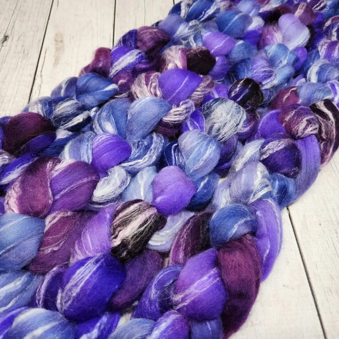 Purple and blue roving on a wooden floor.