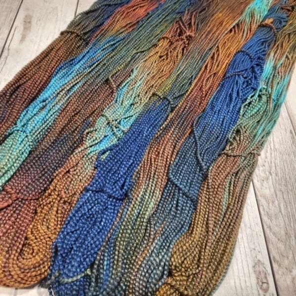 A skein of yarn with blue, orange, and brown colors.