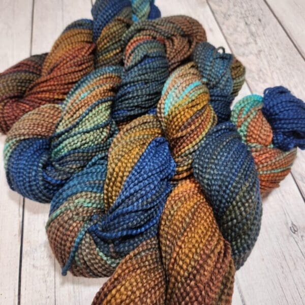 A skein of yarn with blue, brown and orange colors.