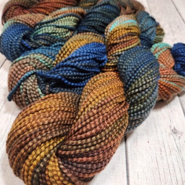 A skein of yarn with blue, brown, and orange colors.