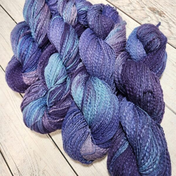 Purple and blue skeins on a wooden floor.