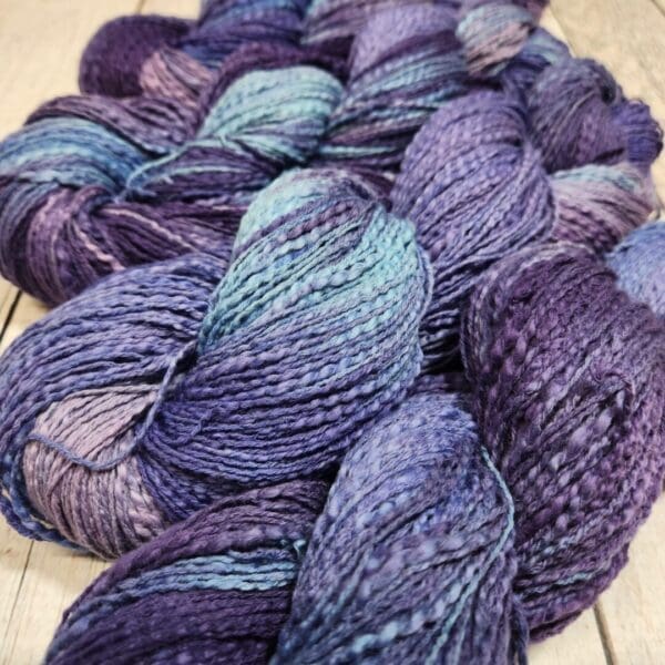 Purple and blue skeins on a wooden table.