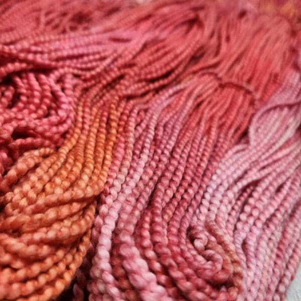 A close up of some pink and orange yarn.