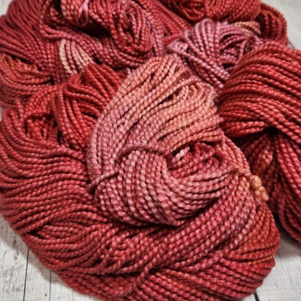 Skeins of red yarn on a wooden table.