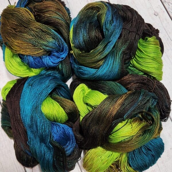 Four skeins of yarn with green, blue and black colors.