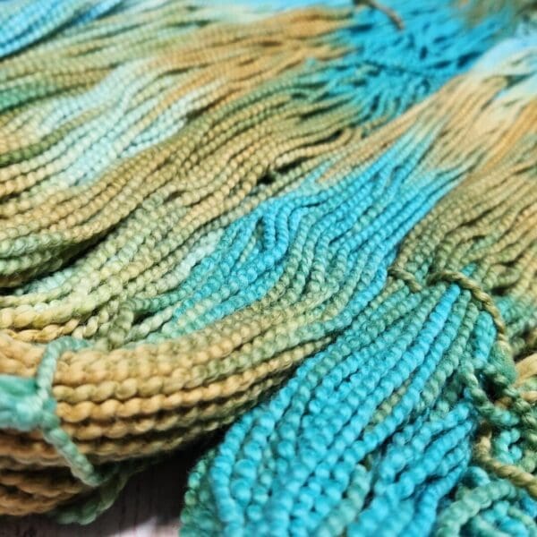 A close up of a blue and green yarn.