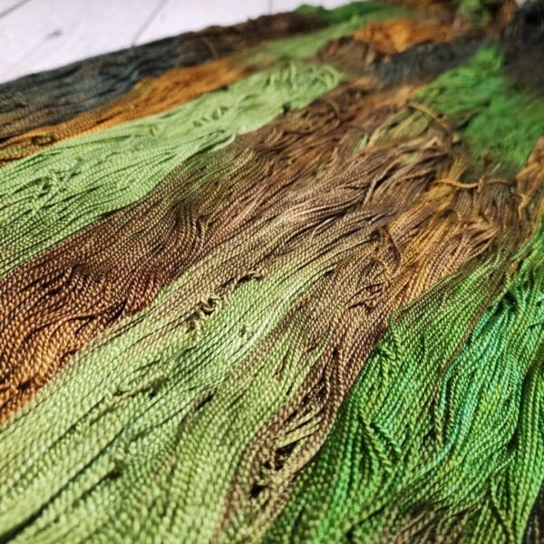 A close up of a green and brown yarn.