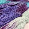 Skeins of purple, blue, and green yarn.