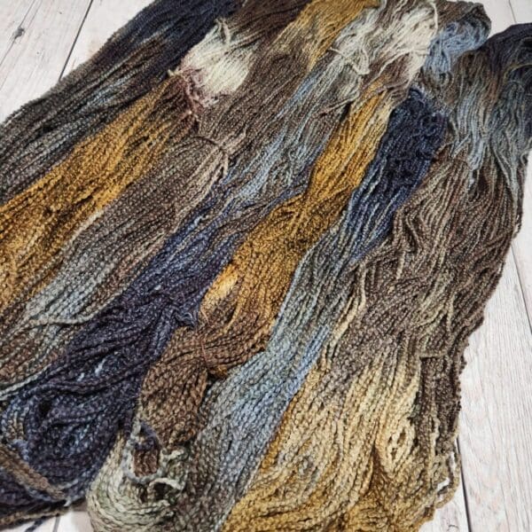 A skein of yarn on a wooden floor.
