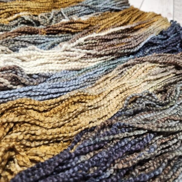 A close up of a bunch of yarn on a wooden floor.