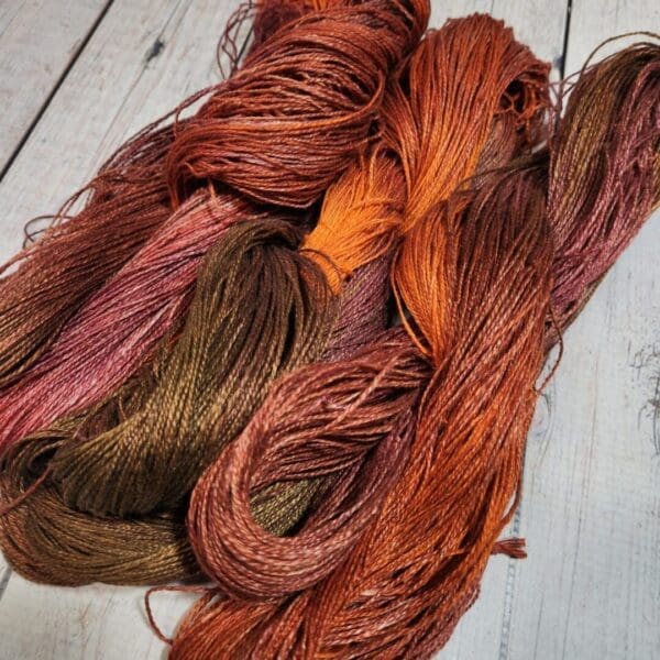 Two skeins of yarn with orange and brown colors.