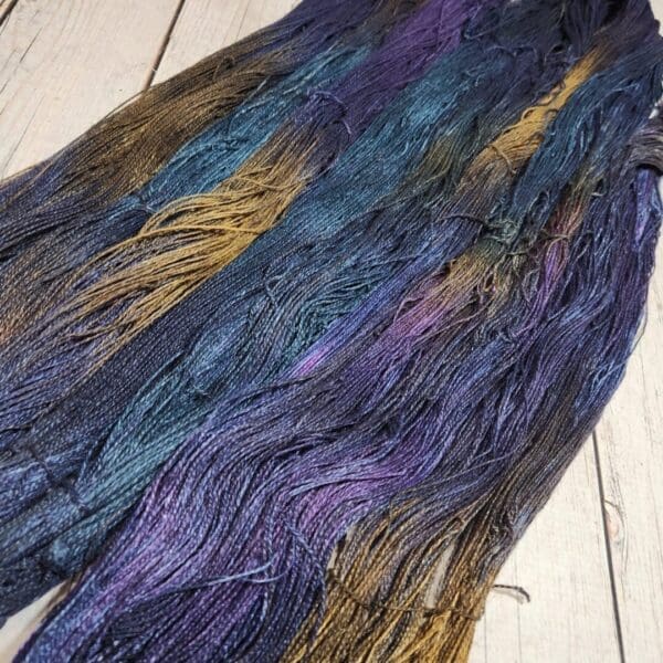 A skein of purple, blue, and yellow yarn.