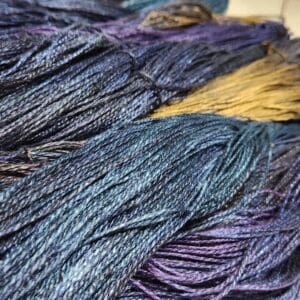 A close up of a skein of blue and yellow yarn.