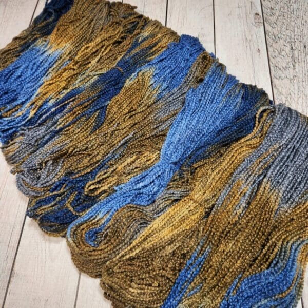 A skein of yarn with blue, yellow and brown colors.