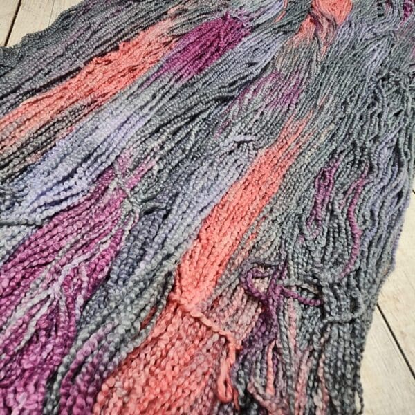 A skein of yarn with purple and pink colors.
