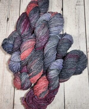 A skein of yarn with purple and grey colors.