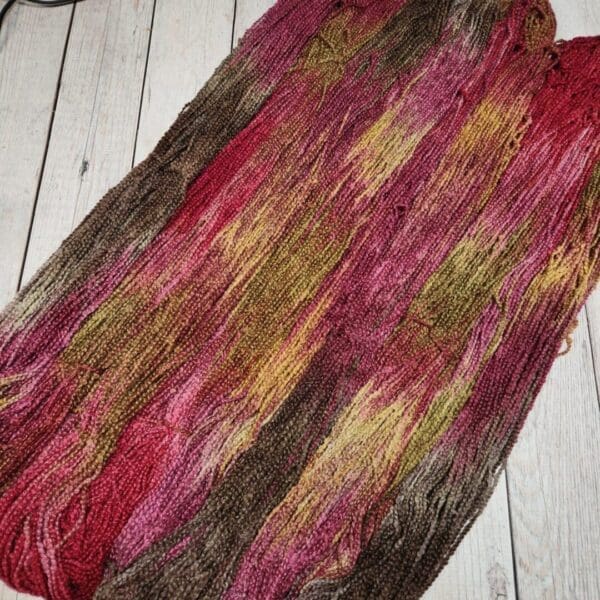 A skein of yarn with red, brown, and yellow colors.