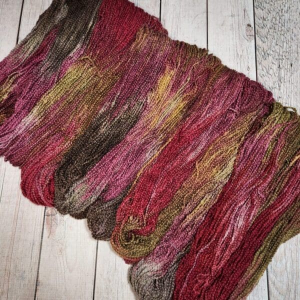 A skein of yarn with red, brown and green colors.