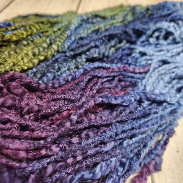 A skein of yarn with purple, blue, and green colors.