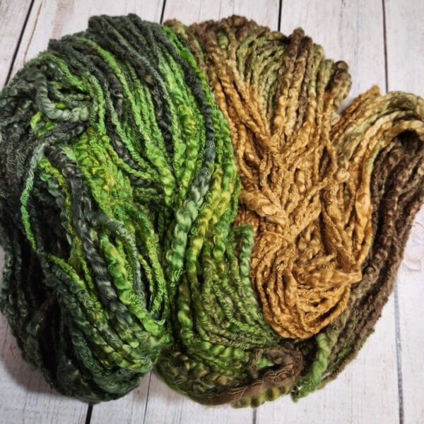 A skein of green and brown yarn on a wooden table.