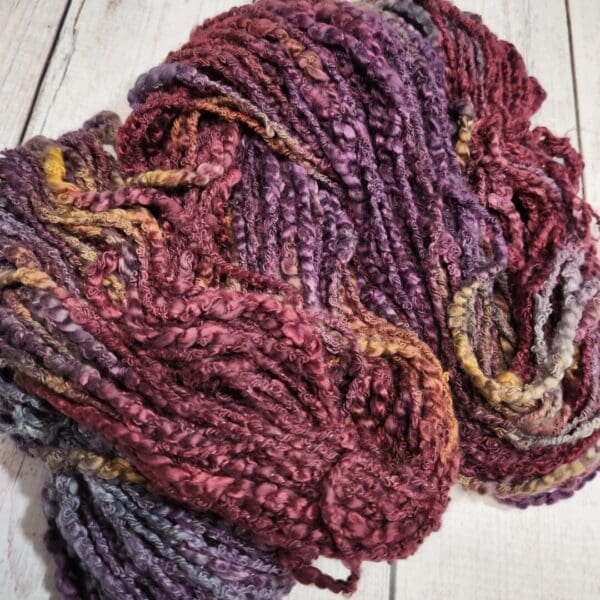 A skein of yarn in a purple and yellow color.