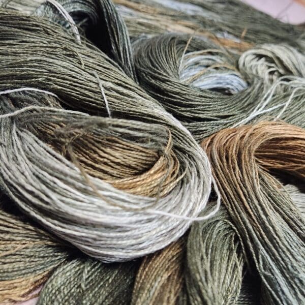 A bunch of grey and brown yarns on a table.