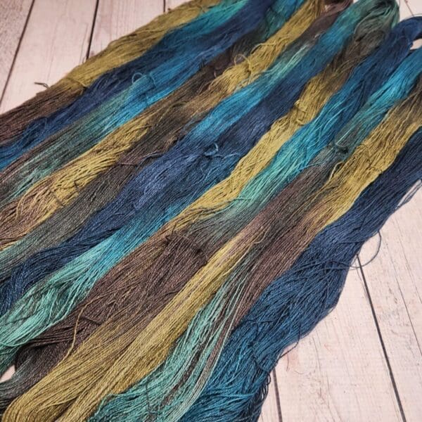 A skein of yarn with blue, green, and yellow stripes.