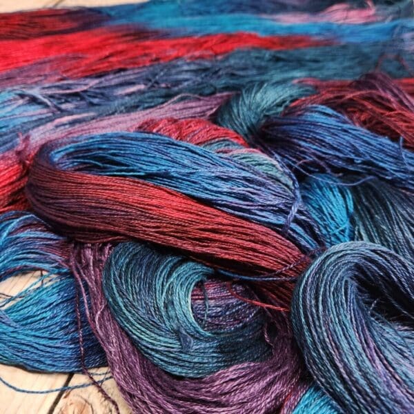 A pile of blue and red yarn on a wooden floor.