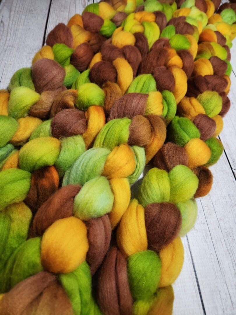 A pile of yellow, green, and brown roving.