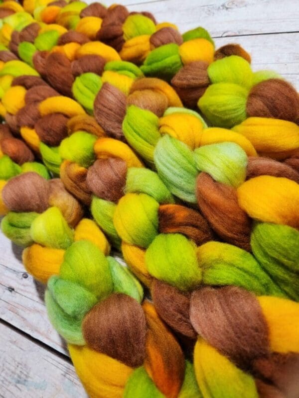 A pile of yellow, green, and brown roving.