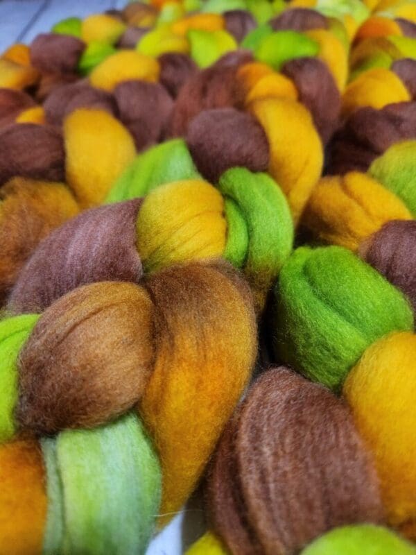 A pile of yellow, green, and brown roving.