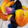 A pile of colorful roving on a wooden table.