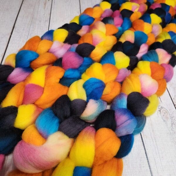 A pile of colorful roving on a wooden table.