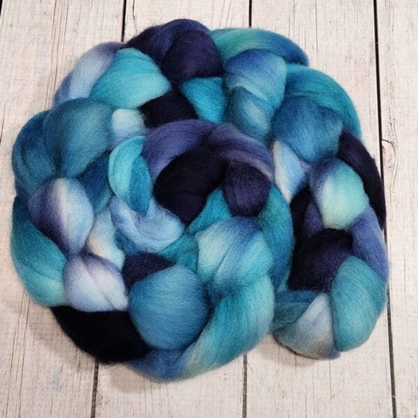 A blue and black roving on a wooden surface.