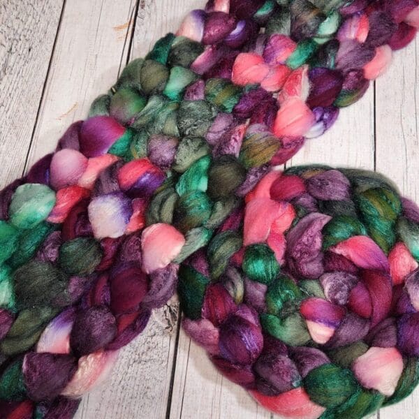 Purple and green roving on a wooden table.