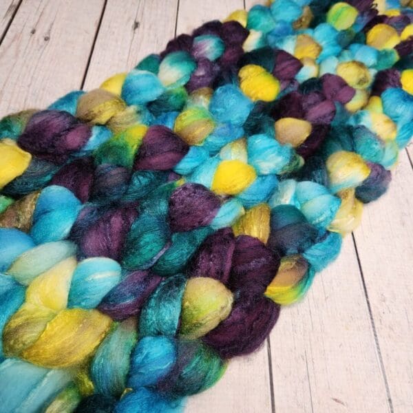 Purple, blue, yellow and green merino wool roving.