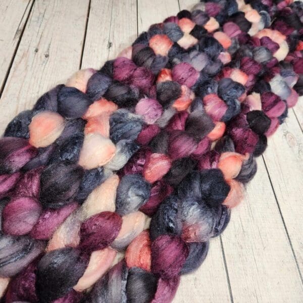 Purple and black roving on a wooden floor.