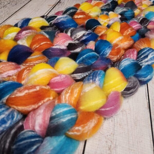 A bunch of colorful wool skeins on a wooden table.