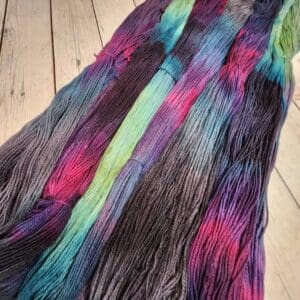 A skein of multicolored yarn on a wooden floor.