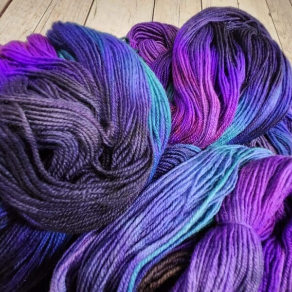 Purple, blue, and black skeins of yarn.