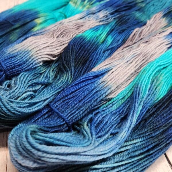 Two skeins of blue and grey dyed yarn.